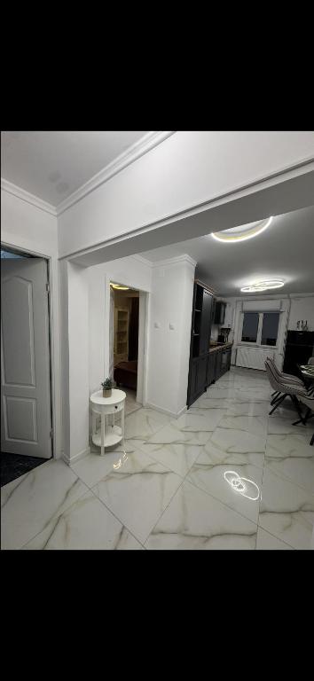a large white room with a table on a tile floor at Nest by Stefan in Drobeta-Turnu Severin