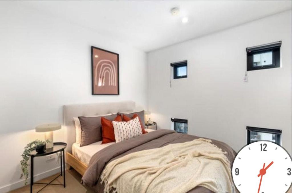 Seffadom apartments Melbourne cbd في ملبورن: غرفة نوم بها سرير وساعة على الحائط