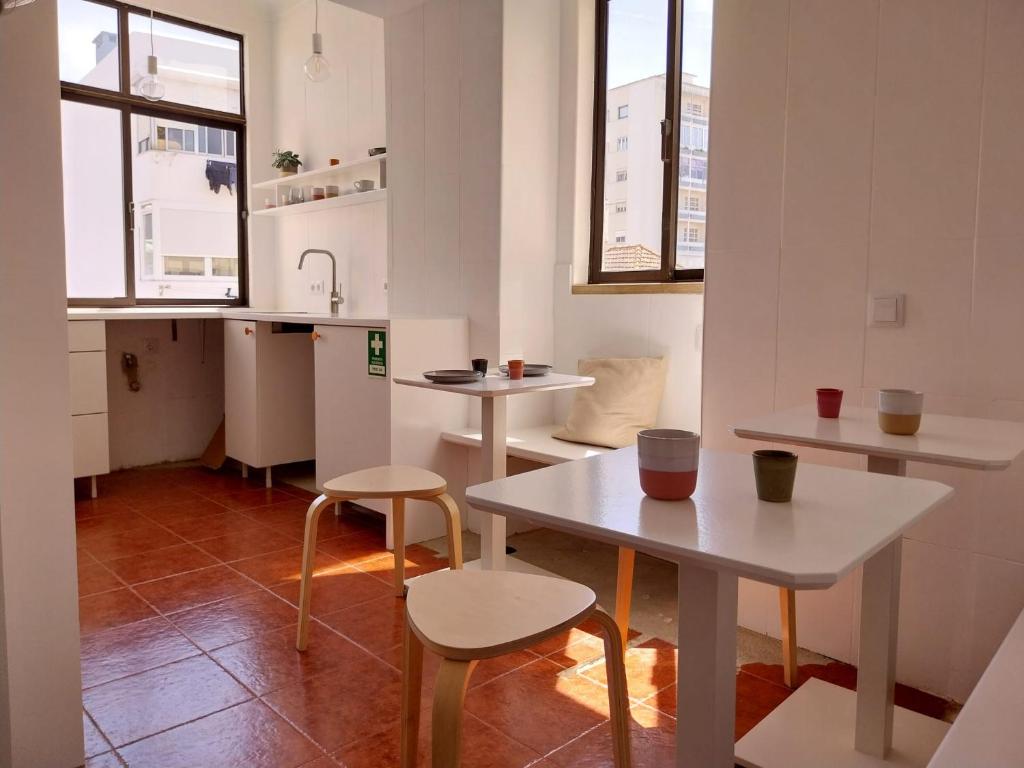 a small kitchen with two tables and two chairs at Stylish Cacilhas rooms near the ferry to central Lisbon in Almada