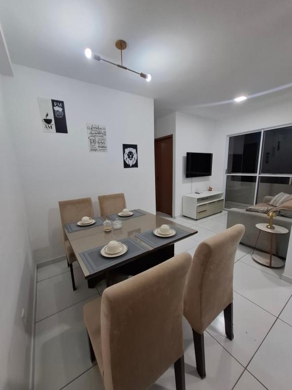 Una mesa de comedor y sillas en una sala de estar. en AP a 3KM das PRAIAS, com SUÍTE, en São Luís
