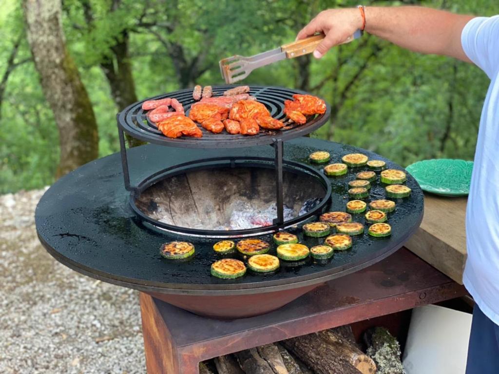 a person is cooking food on a grill at Domaine de pierre blanche in Pern