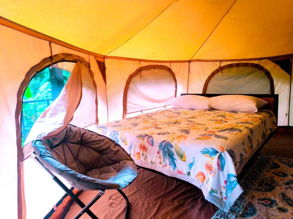 Un dormitorio con una cama en una tienda de campaña. en Monstera Forest Lodge, en Fortuna