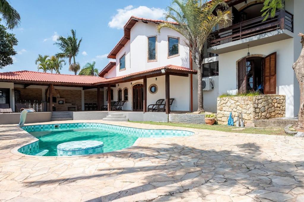 a house with a swimming pool in front of a house at Casa de Campo c 4 Suites AC Wi-Fi em Sao Roque in Mairinque