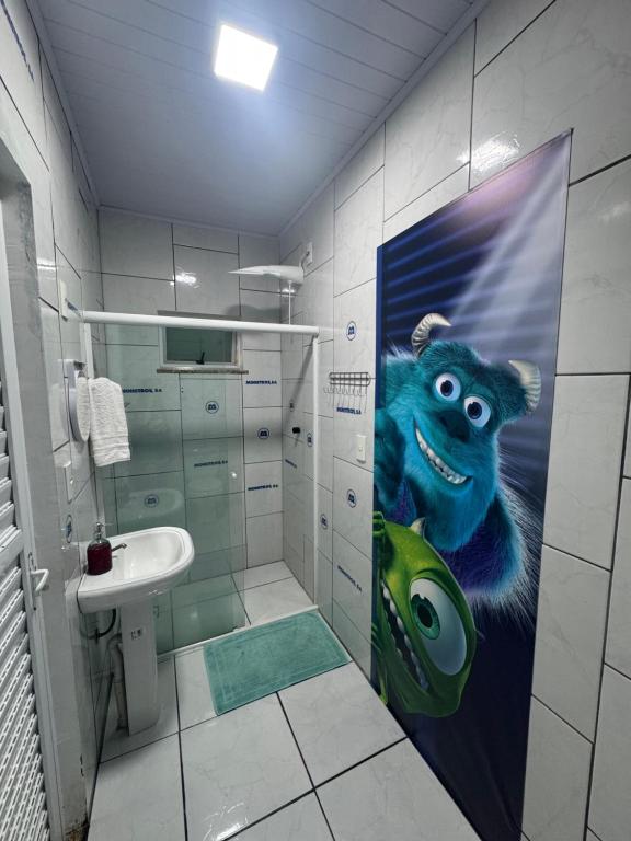 a bathroom with a painting of a monkey on the wall at Suíte Monstros SA - Pousada Castelo do Luar in Penha