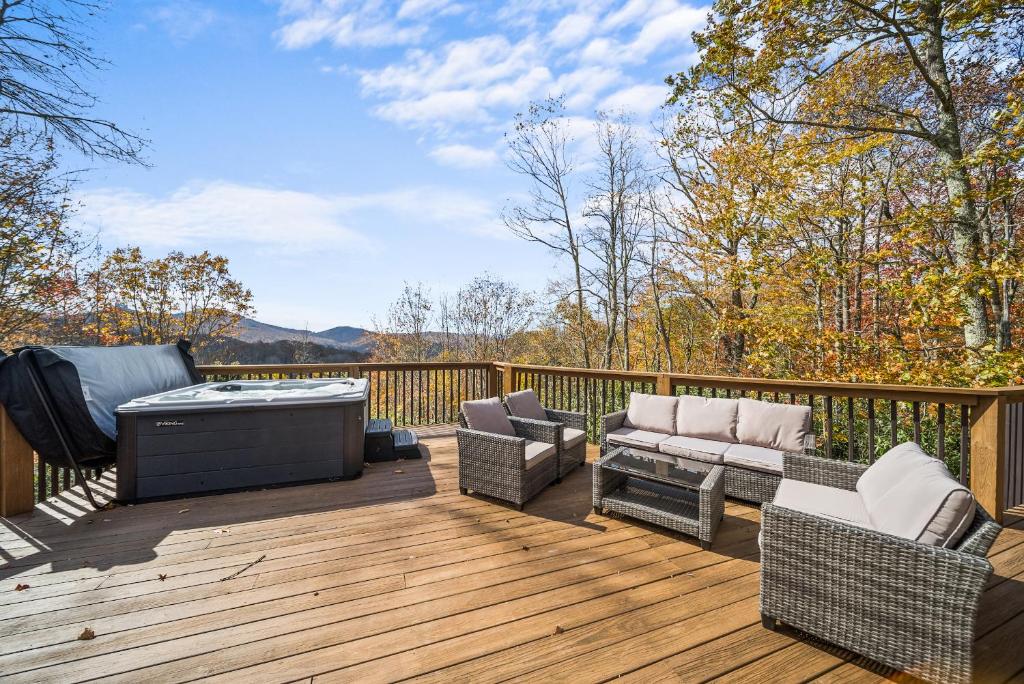 a deck with a hot tub and furniture on it at Sugar View Chalet in Banner Elk