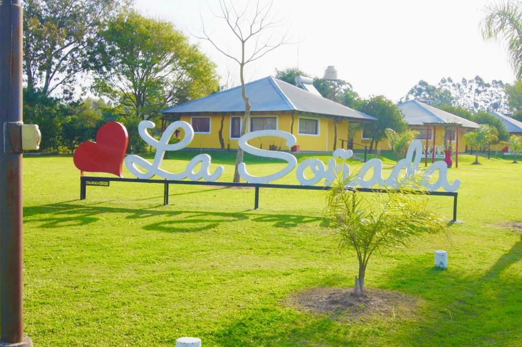 um parque com um banco com uma placa que diz excelência em Cabañas La Soñada em Chajarí