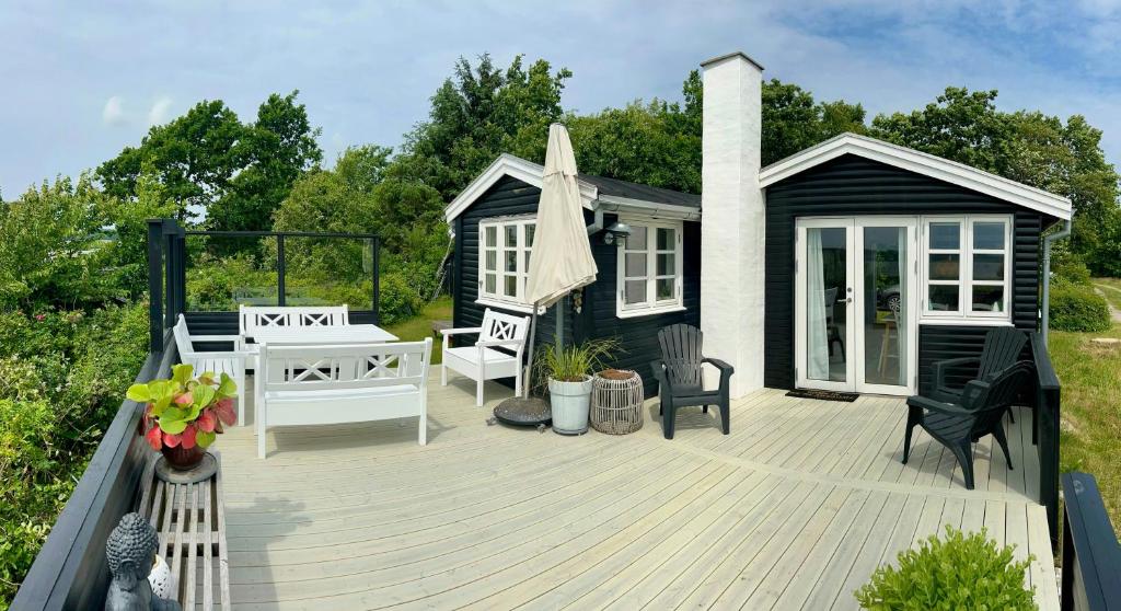 a deck with a black and white house at 180 Degree View Over Sebbersund Fjord in Nibe