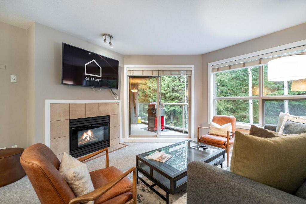 a living room with a fireplace and a tv at Aspens Lodge 220 by Outpost Whistler in Whistler