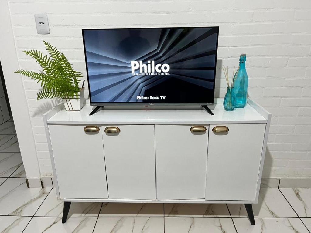 a white cabinet with a tv on top of it at Casa próximo à rodoviária e centro in Rondonópolis