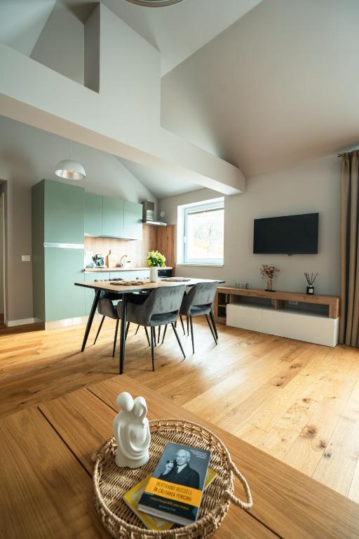 a living room with a table and a tv at The Nest Beneath the Citadel - 5 min to City Square in Râşnov