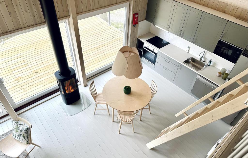 une cuisine avec une table, des chaises et une cuisinière dans l'établissement Stunning Home In Myggenäs With Sauna, à Höviksnäs
