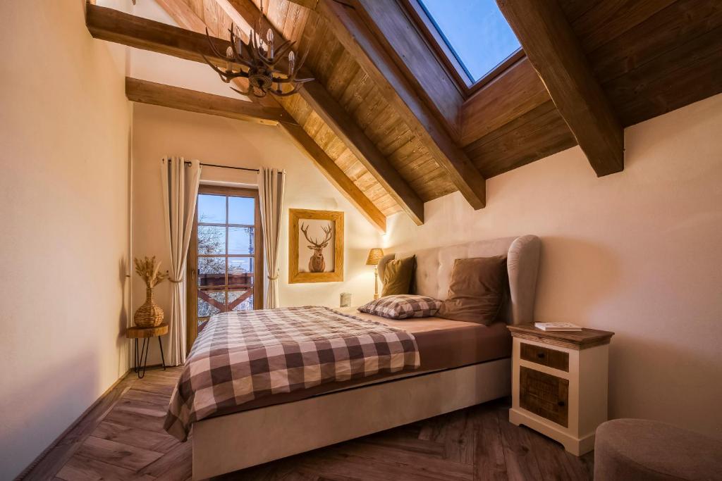 a bedroom with a bed and a ceiling with a window at Deer Apartment in Lipí