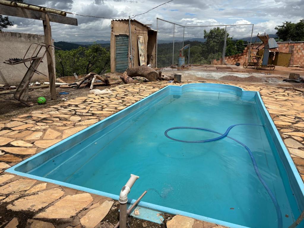 São Joaquim de BicasにあるRancho do solの石の床にホースで水を張ったプール