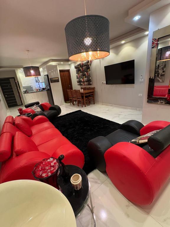 a living room with red couches and a television at Stella Heights in El Alamein