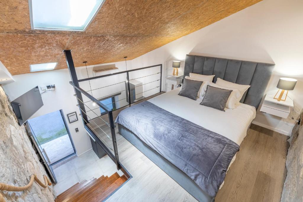 ein Loft-Schlafzimmer mit einem Bett und einer Treppe in der Unterkunft Lapa 4 House in Porto