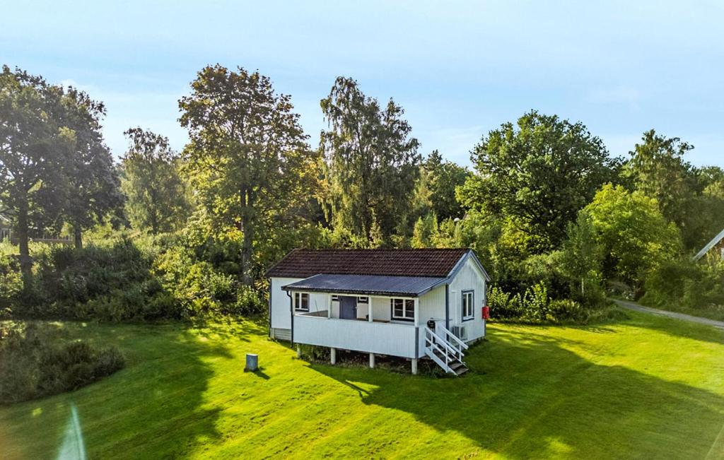 a small white house on a grass field at Stunning Home In Myggenäs With Sauna in Höviksnäs