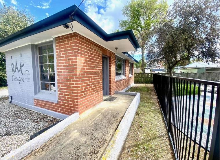 a small brick house with a fence next to it at The Batch in Lawrence