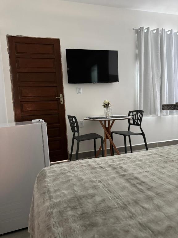 a bedroom with a bed and a table and chairs at Pousada Oito Mares in Arraial do Cabo