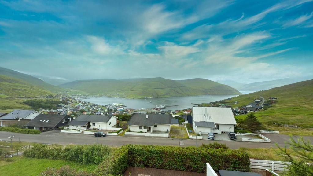 Exclusive Modern Villa with Panoramic Views في Vestmanna: مدينة بها مسطح مائي وجبال