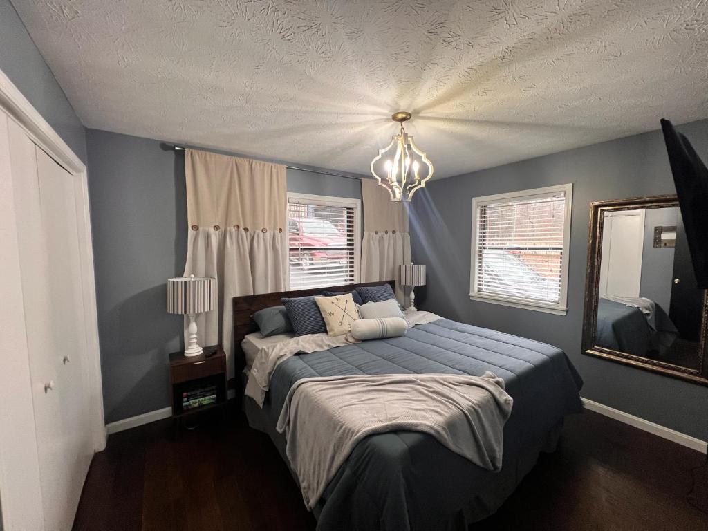 een slaapkamer met een bed met blauwe muren en een kroonluchter bij Panoramic Point--PERFECT views of Rough River in Falls of Rough