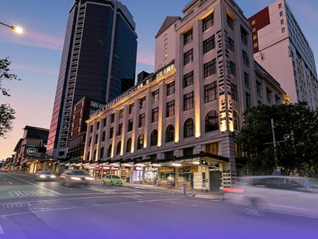 a building on a city street with cars at Attic Backpackers in Auckland