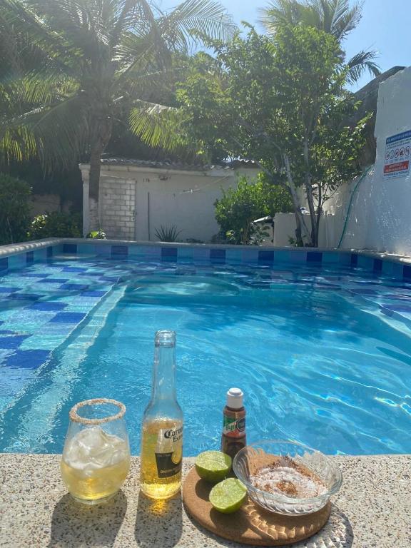 a drink and a bowl of food next to a swimming pool at Casa campestre Magyli in Puerto Salgar