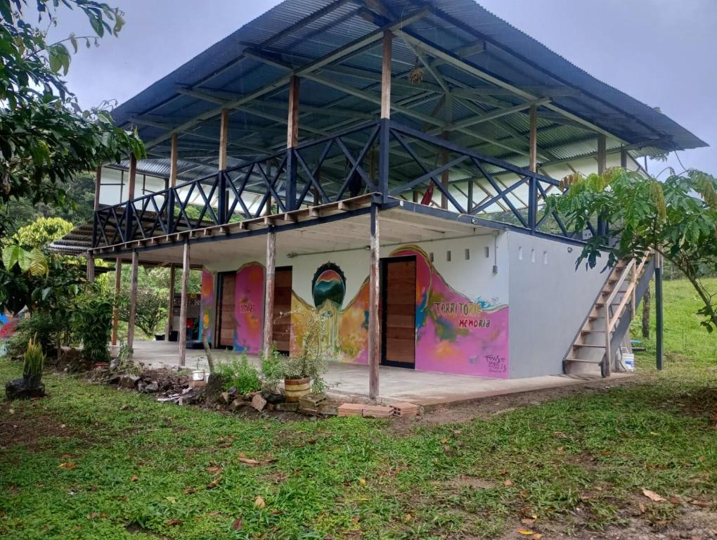 une maison avec une fresque murale sur son côté dans l'établissement El portal de la montaña, à Estación El Salto