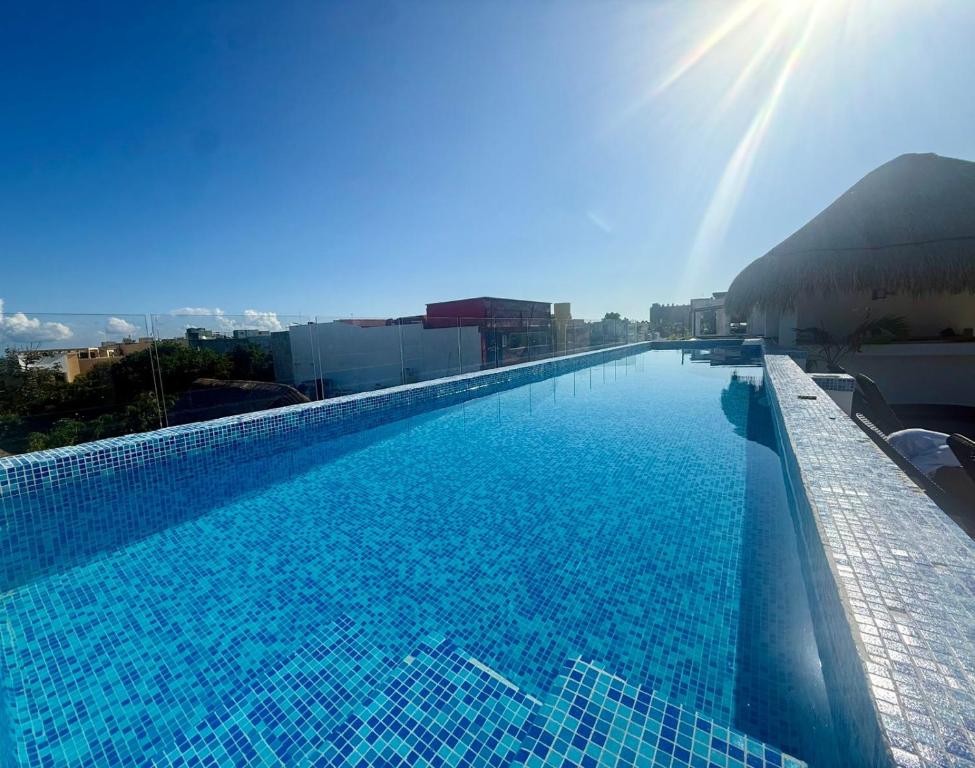 CASA TORTUGA 5Th Ave في بلايا ديل كارمن: مسبح ازرق كبير فوق مبنى