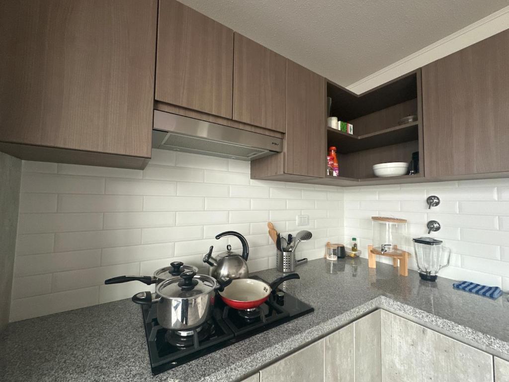 een keuken met een fornuis met potten en pannen erop bij Luxury Duplex on the 15th Floor with Terrace in Lima