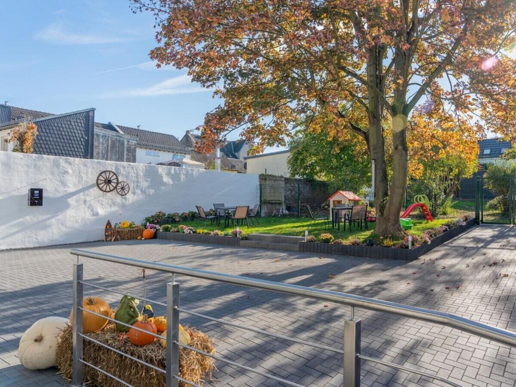 Holiday home Ahorn ground floor في Weilerswist: حديقة بها قرع وملعب