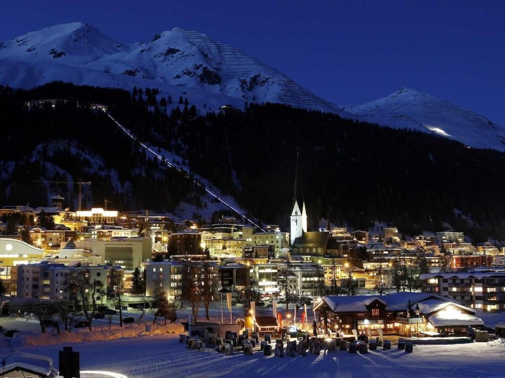 a town in the snow at night with a mountain at Holiday apartment Constantin in Davos