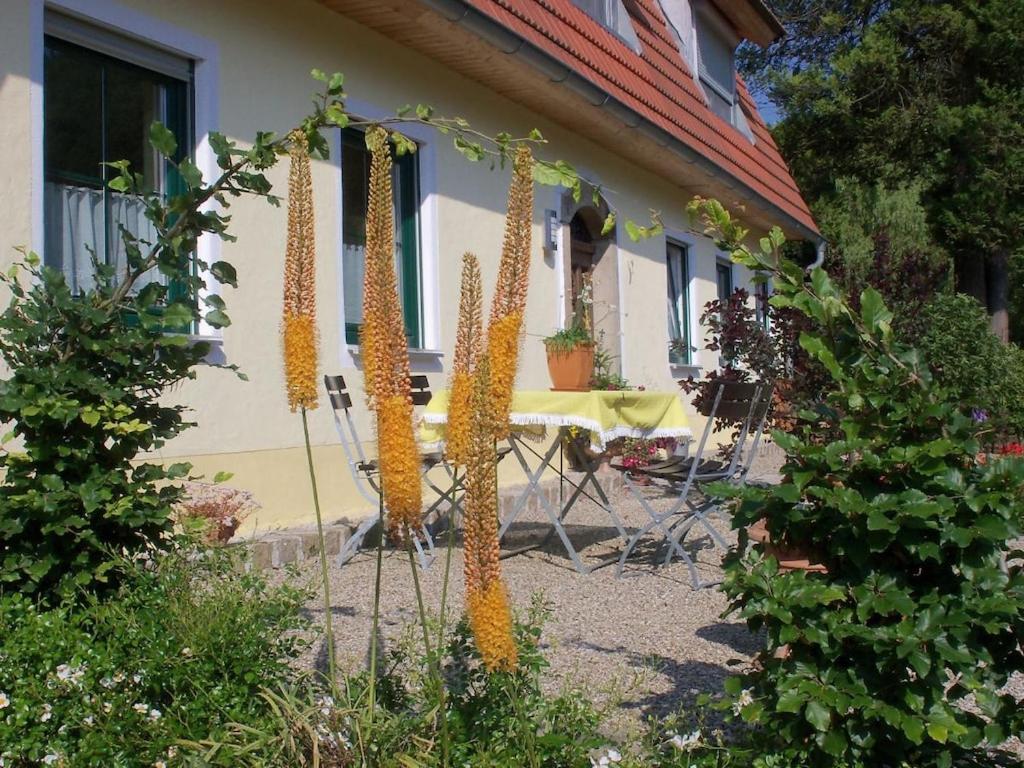a garden with a table and flowers in front of a house at Holiday apartment with 1 bedroom in Furth im Wald