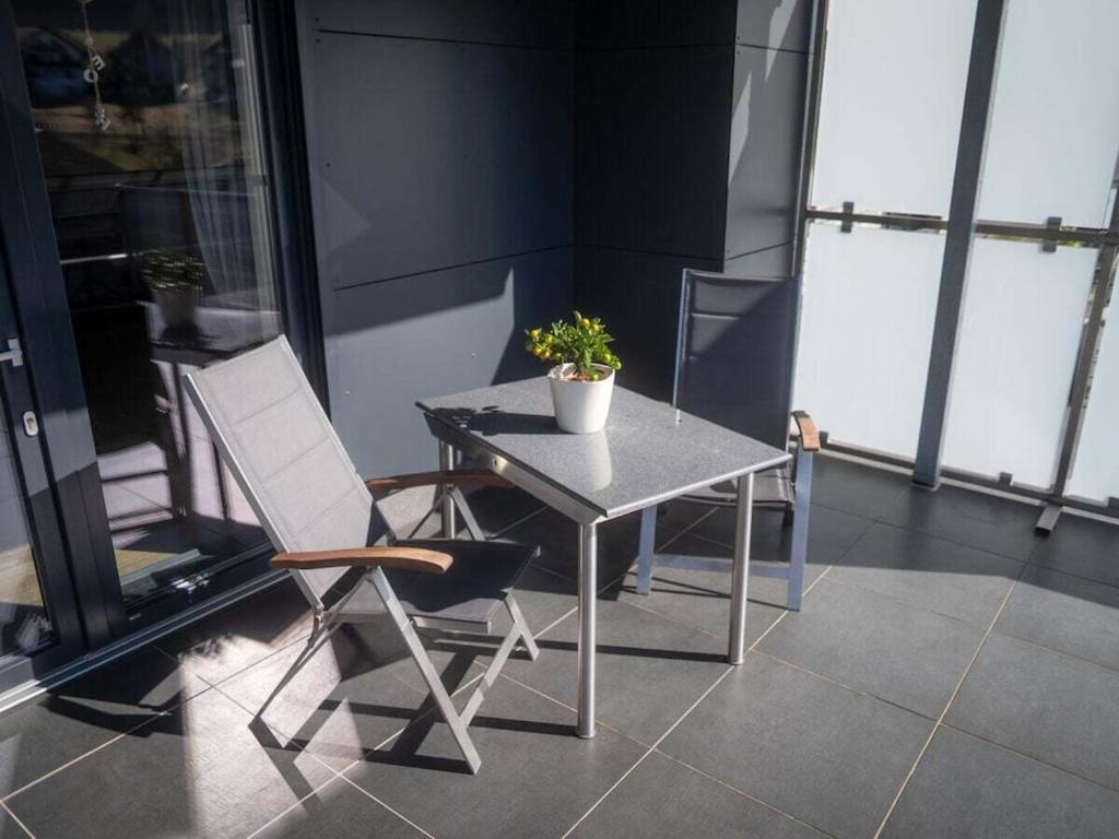 a table and chair with a potted plant on a balcony at Apartment with 1 bedroom in Einruhr