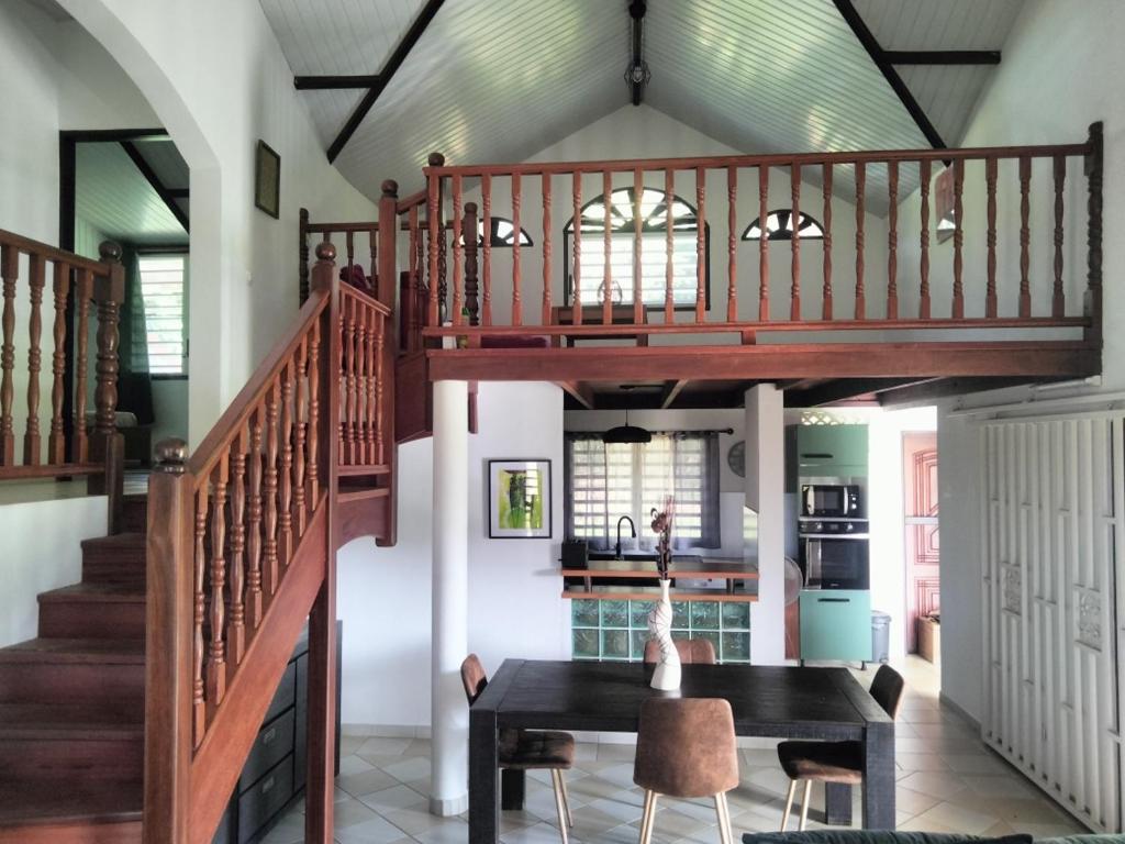 a dining room with a staircase and a table at La mélodieuse in Macouria