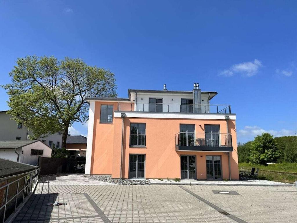 een roze gebouw met een balkon erboven bij Penthouse sea view in Lauterbach