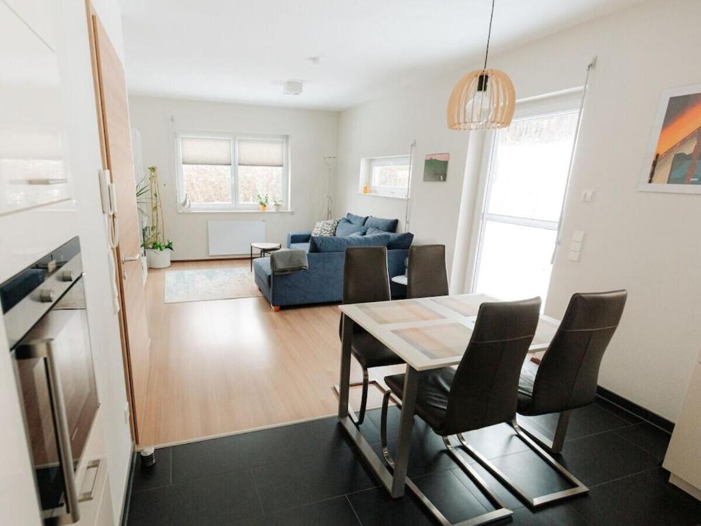 a living room with a table and a blue couch at Alb holiday home Zinnäcker in Trochtelfingen