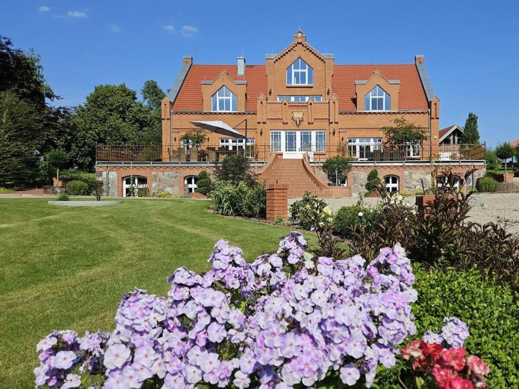 a large house with flowers in front of it at Manor house apartment in Barlin