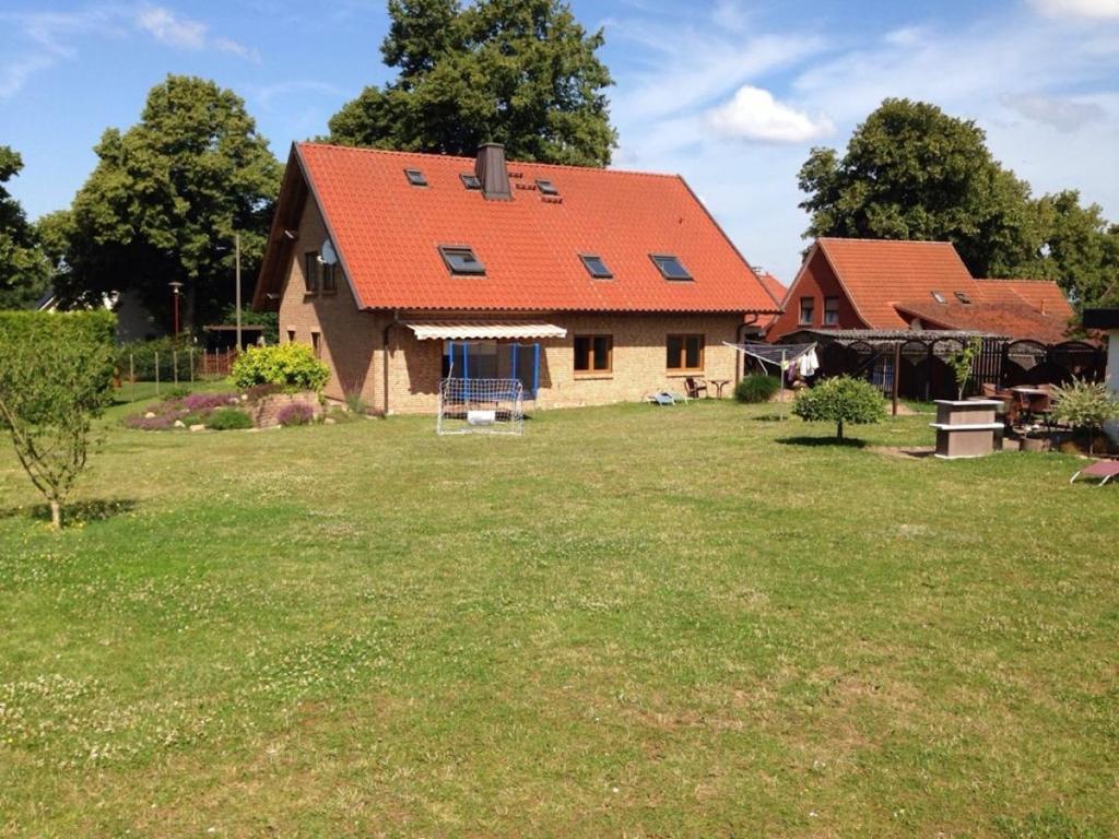 a house with an orange roof in a yard at Holiday apartment with 3 bedrooms in Holzendorf