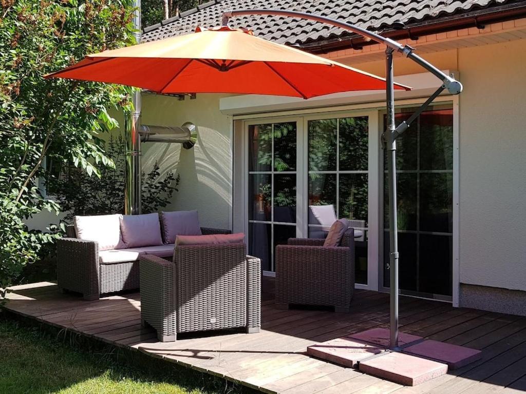 a patio with an umbrella and chairs and a table at Holiday home with 3 bedrooms in Fichtenwalde