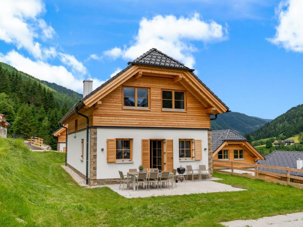 a house on a hill with tables and chairs at Chalet Pretzel in Donnersbachwald