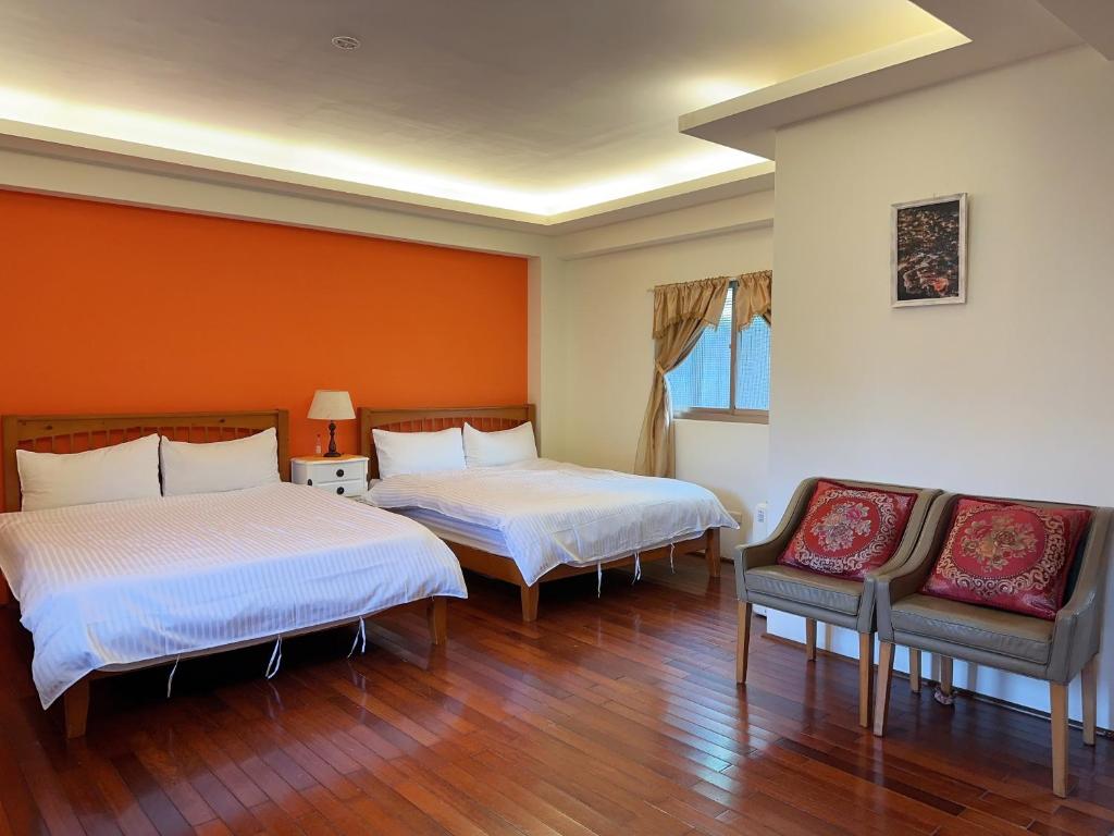 Habitación con 2 camas y 2 sillas. en Jiufen Golden House, en Jiufen