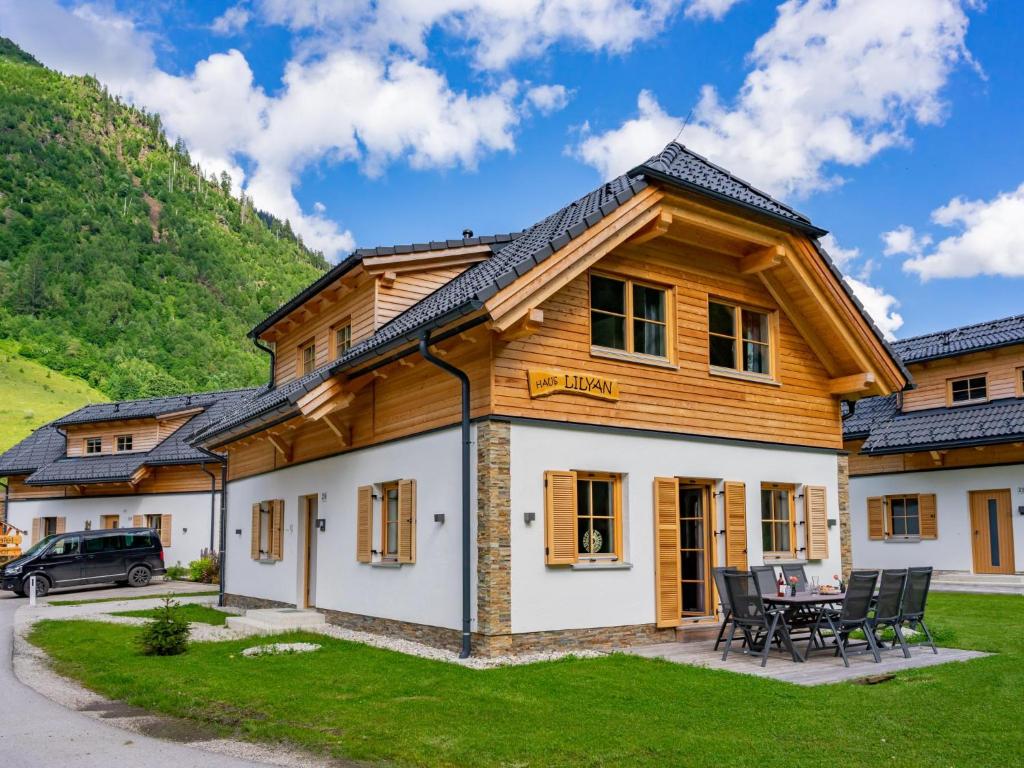 a log home with a table and chairs in the yard at Haus Lilyan in Donnersbachwald