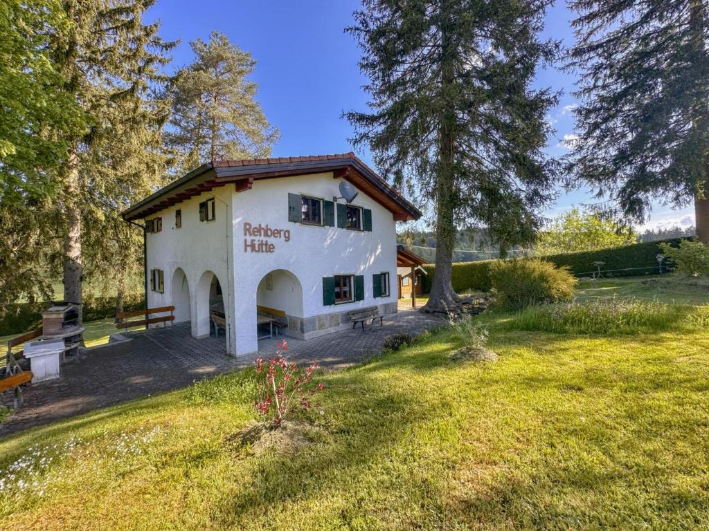 a white building with a picnic table in a field at Rehberg Hütte in Georgenberg