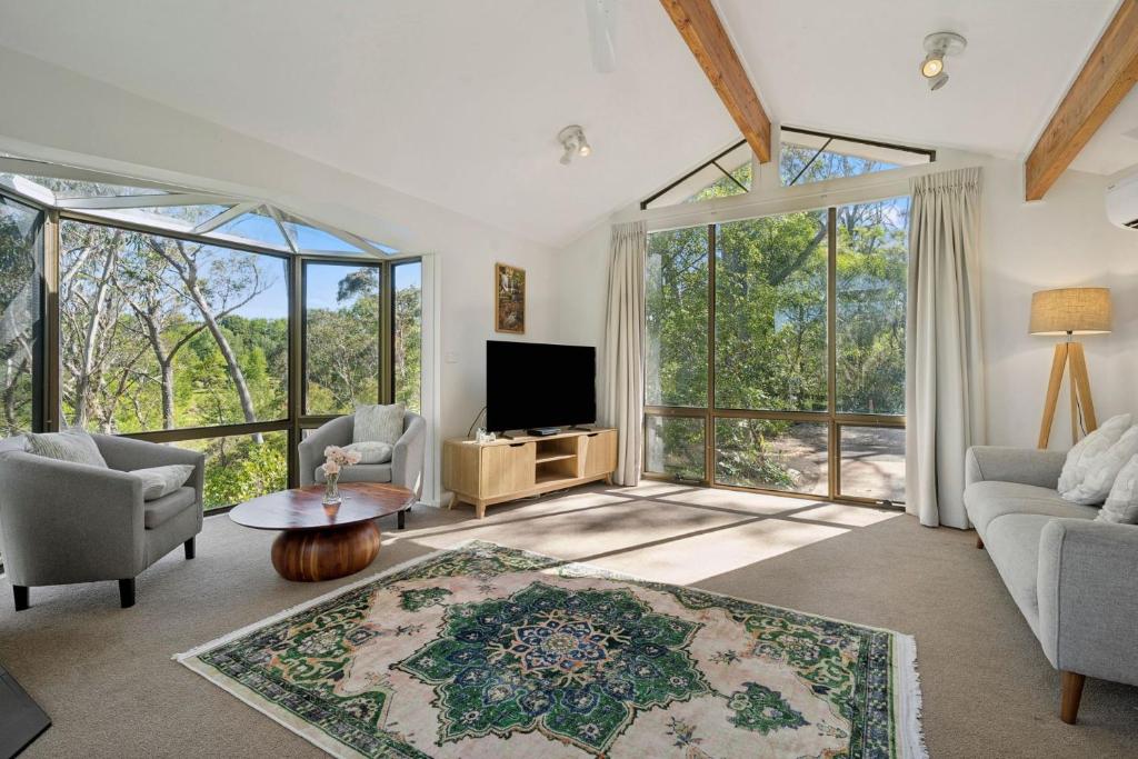 a living room with a tv and large windows at Alencon in Blackheath