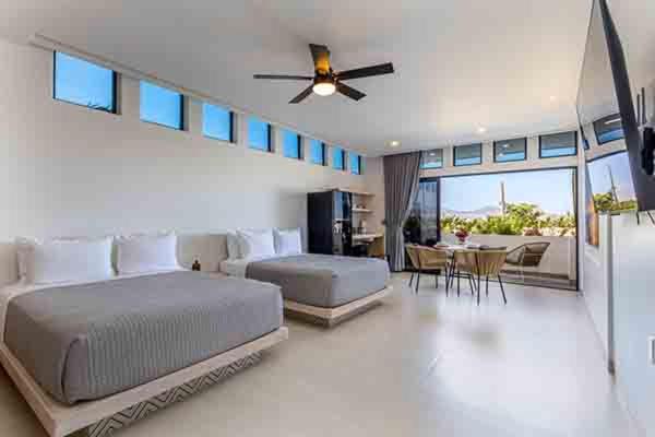 a bedroom with a large bed and a dining room at 605 Tower Downtown Cabo in Cabo San Lucas