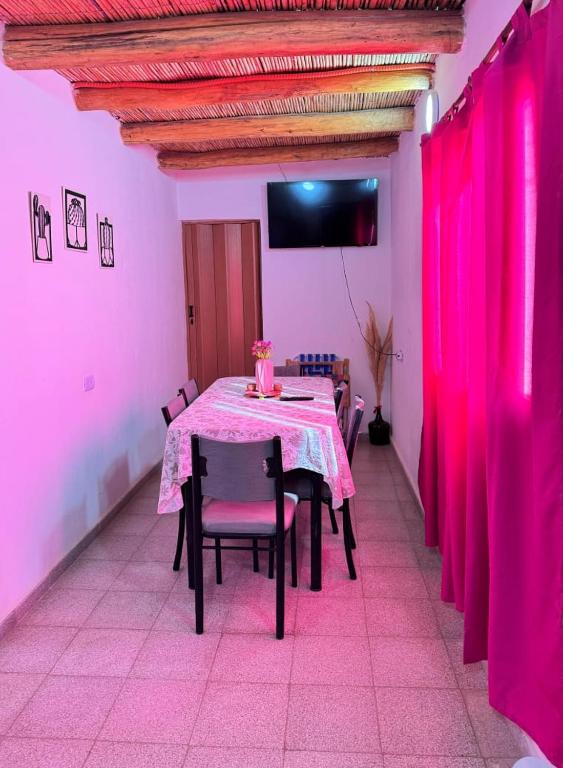 a dining room with a pink table and chairs at Departamento Guadalupe in Fiambalá