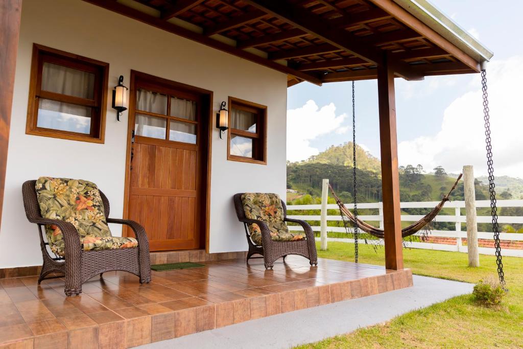 two chairs on the porch of a house at Chalés Ninho do Poeta in Gonçalves