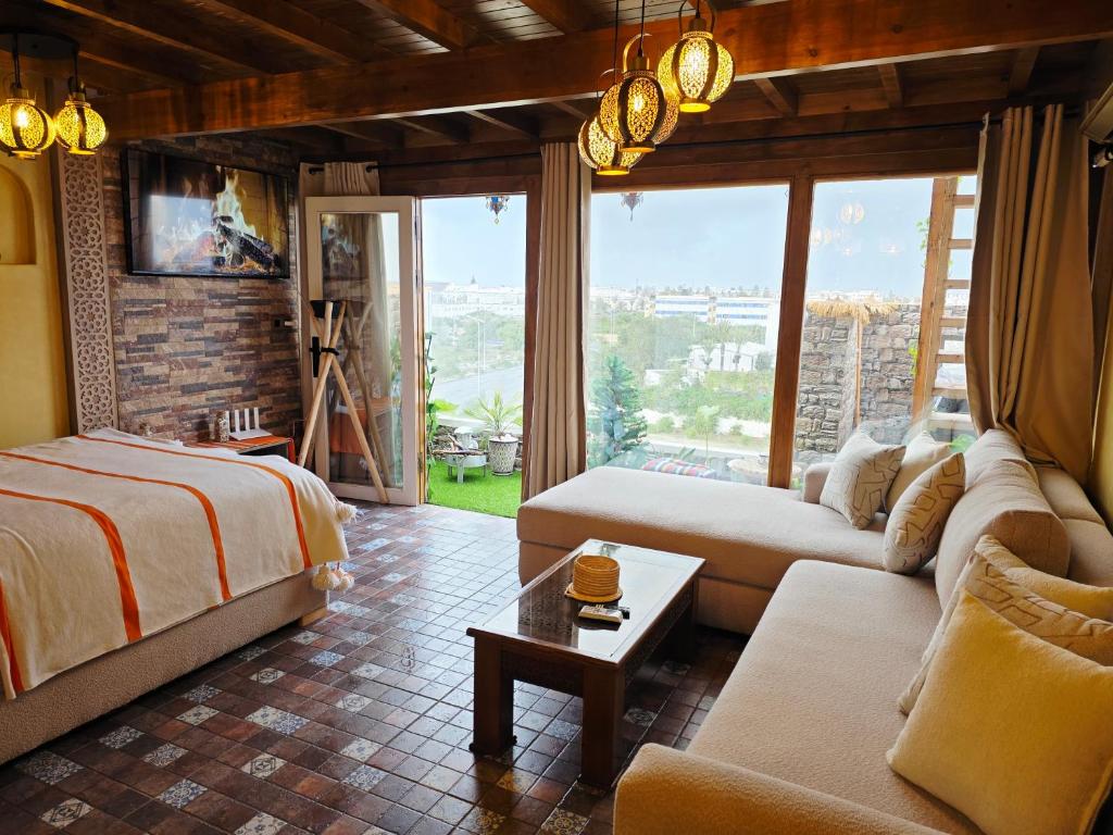 um quarto com uma cama, um sofá e uma mesa em Rooftop studio with ocean view em Essaouira