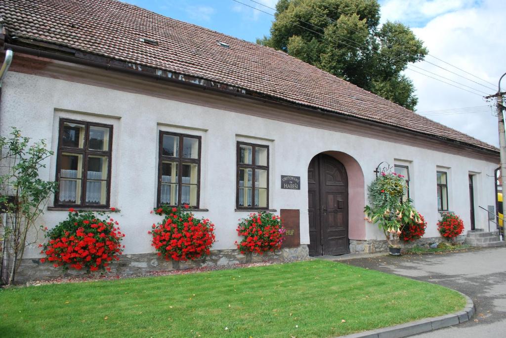 a white house with red flowers in front of it at Rodinné ubytování na Habeši in Crhov