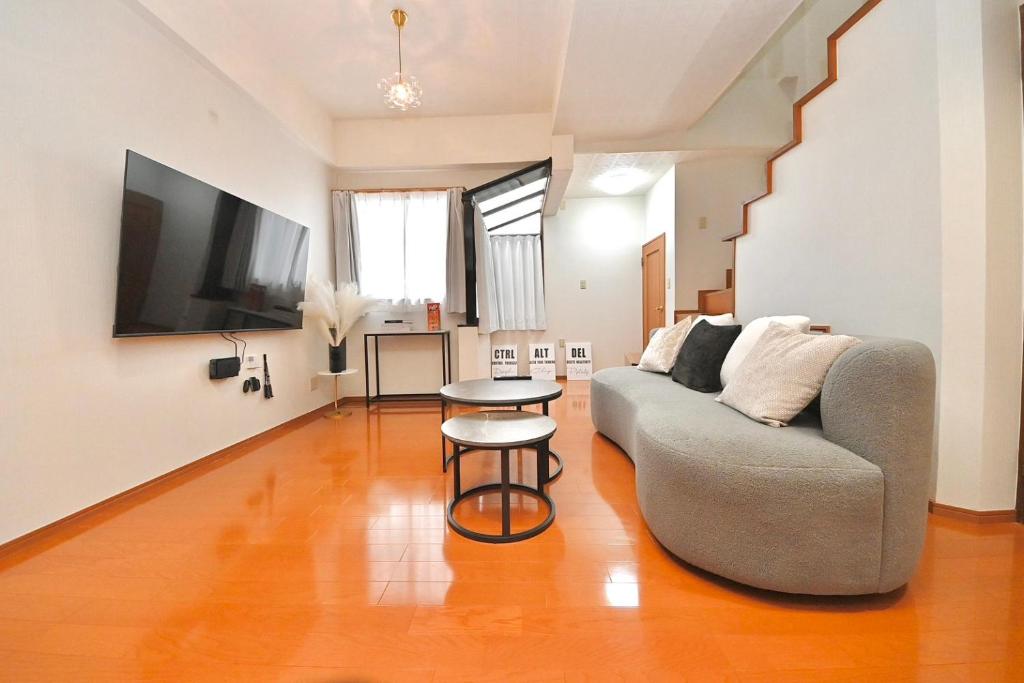 a living room with a couch and a table at LIJ Stay Morinomiya 5BedRooms in Osaka